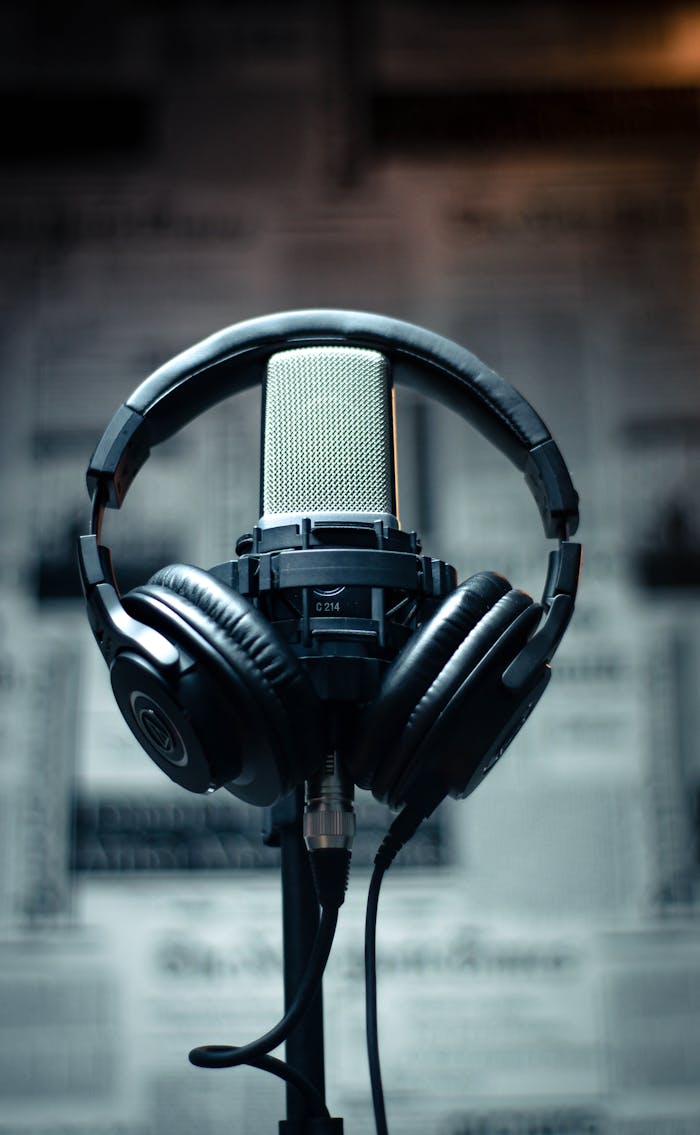 who-we-are Microphone with headphones in a studio environment, perfect for sound recording and podcasting.